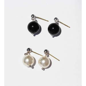 Minimalist pearl and black onyx drop earrings set in silver finish on white background
