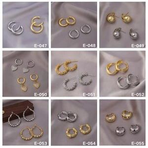 Collection of golden and silver earrings with heart pendants and textured hoops