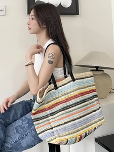 Large woven tote bag with colorful stripes and black shoulder straps for beach