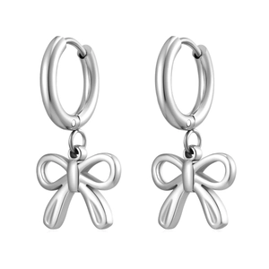 Detailed close-up of silver bow pendant earrings with high-polish finish on white background