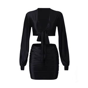 Close-up of black satin long sleeve wrap top and ruched mini skirt two-piece set