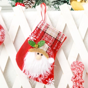 Detail of red Santa Claus Christmas stocking with plaid pattern on white fence