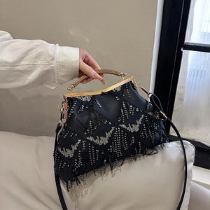 Detail of vintage black shell bag with sequins, gold clasp frame and fringe tassels