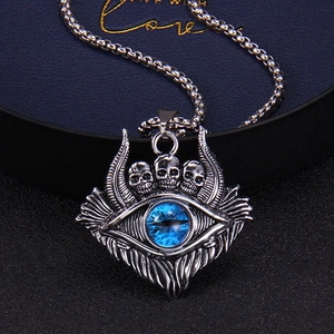 Detailed close-up of retro skull and blue devil eye pendant on a silver box chain