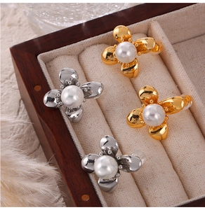 Macro view of gold and silver flower pearl stud earrings in a wooden jewelry box