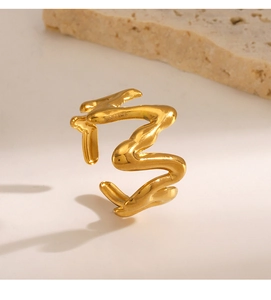 Detailed view of an irregular 18K gold plated lava ring on a decorative stone base