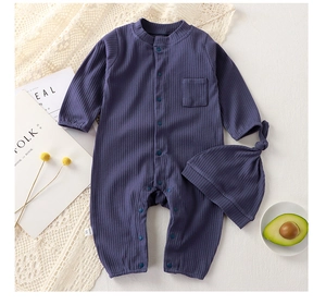 Flat lay of ribbed cotton baby romper and matching knotted hat with snap buttons