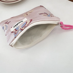 Detailed view of butterfly jacquard fabric and pink braided strap on a small shoulder bag