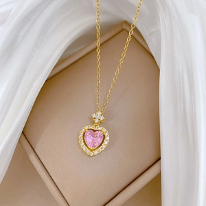 Detail of pink heart pendant necklace with rhinestones in a beige luxury jewelry box