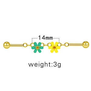 Détail du piercing industriel doré de 14mm avec breloques marguerites vertes et jaunes
