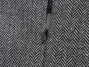 Detail view of black and white herringbone fabric featuring a hidden zipper component