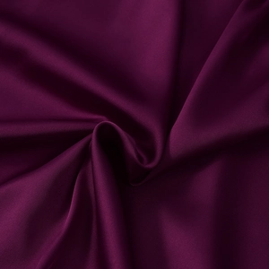 Close-up of deep purple satin fabric showing silky texture and elegant draping detail