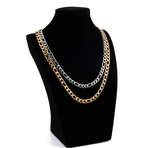 Detailed close-up of gold and silver Figaro link necklaces on a black neck display