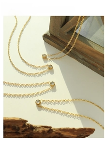 Detailed view of 18K gold plated titanium necklace with brilliant round cubic zirconia