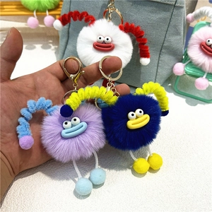 Close-up of a colorful plush monster keychain with spring antennas and soft fur texture