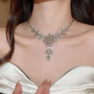 Elegant model wearing a silver floral rhinestone necklace with sparkling drop pendant
