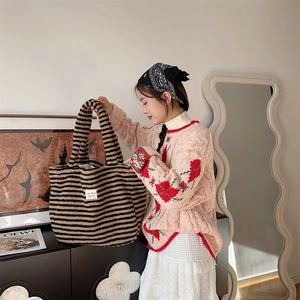 Detail of plush tote bag with black and khaki stripes and GOUZHU brand label