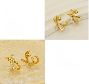 Close-up of gold X-cross pearl earrings with sparkling zircon stones in a macro view