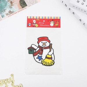 Autocollants de fenêtre bonhomme de Noël avec emballage festif rouge sur un bureau blanc