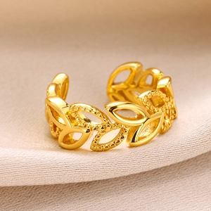 Detail of gold hollow leaf ring featuring intricate milgrain edges on silk background