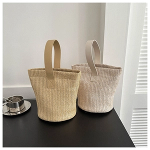 Detailed close-up showing woven straw texture and bucket shape of these beach handbags