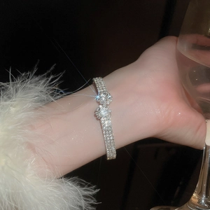 Detail of elegant silver bracelet with sparkling pavé diamonds and a central pearl accent