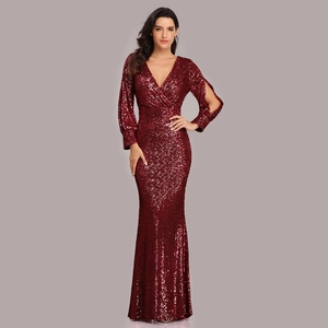 Close-up of sparkling burgundy sequins on long sleeve V-neck mermaid evening gown