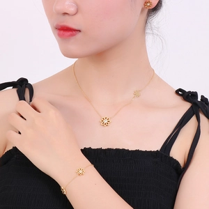 Detail of gold daisy jewelry set featuring flower necklace and bracelet on model