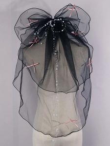 Detail of four-layer black bridal veil with scattered pearls and pink satin bows
