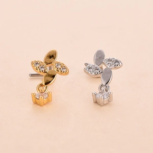 Macro detail of L-shaped nose studs with cross leaf design and micro-set cubic zirconia