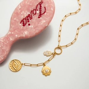 Detail van 18K goud roestvrijstalen Hamsa Hand en Evil Eye hangers aan een paperclip ketting