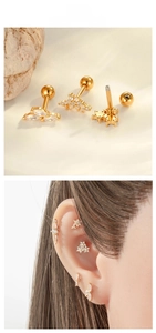 Macro view of gold stainless steel cartilage studs with cubic zirconia flower and star shapes