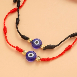 Dettaglio di bracciali malocchio intrecciati con perline di vetro e distanziatori