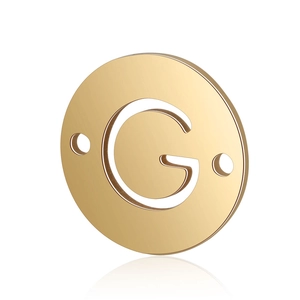 Macro shot of gold-plated stainless steel round pendant with hollow letter G