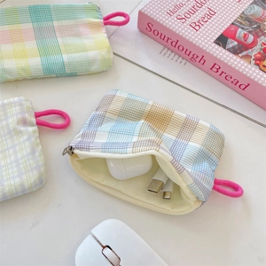 Internal view of checkers print fabric pouch storing headphones and USB cable