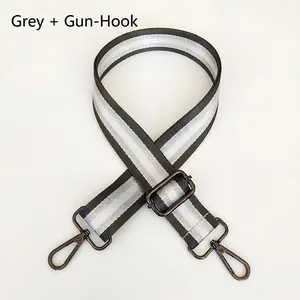 Close-up of adjustable grey and silver striped nylon bag strap with gunmetal hardware