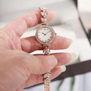 Detail of rose gold mermaid watch with crystal accents and leaf-shaped bracelet links
