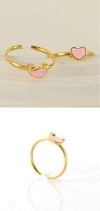 Detail showing adjustable gold heart and pink whale enamel ring on white porcelain