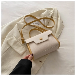 Detail of lychee textured cream handbag with yellow piping and metal buckle detail