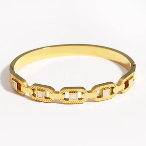 Détail du bracelet en acier titane doré orné d'incrustations carrées en nacre blanche