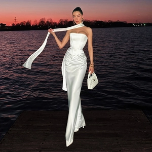 Dettaglio dell'abito in raso bianco con vita a corsetto e nastri eleganti in riva al lago