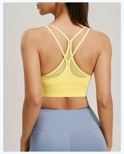 Macro view of neon yellow sports bra back with breathable mesh panels and crisscross straps