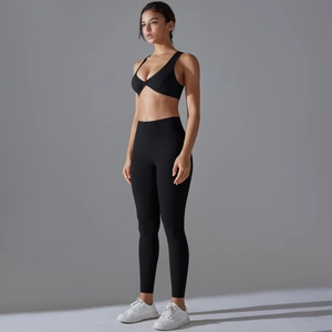 Side view of black yoga set featuring a front-knot sports bra and high-waisted leggings