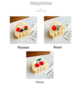 Detailed views of small acetate hair claws with cherry, rose, and floral patterns