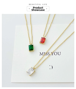 Detalle de collares con colgante rectangular de esmeralda y rubí sobre una tarjeta