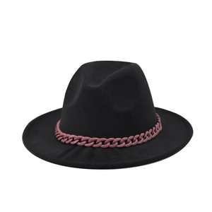 Détail d'un chapeau fedora noir en feutre avec une chaîne décorative rose vif tendance
