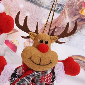 Close-up of a plush Christmas reindeer ornament with red nose and checkered scarf