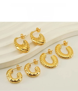 Detailed macro view of 18K gold-plated U-shaped earrings with shell and hammered textures