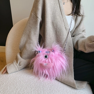 Detail of pink furry monster crossbody bag shown with soft texture and creative long braids