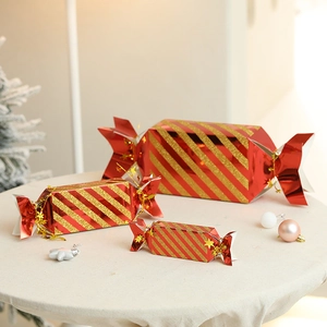 Three red and gold striped candy-shaped Christmas gift boxes in small, medium, and large sizes